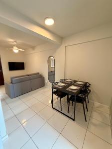 a dining room with a table and chairs and a couch at Apto com 2 quartos e A/C ao lado da Santa Casa in Montes Claros