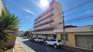 two white cars parked in front of a building at Apto com 2 quartos e A/C no Centro in Montes Claros