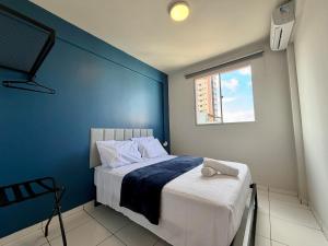 a bedroom with a bed with a blue wall at Apto com 2 quartos e A/C no Centro in Montes Claros