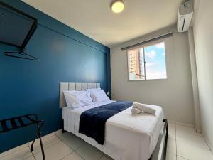 a bedroom with a blue wall and a bed at Apto com 2 quartos e A/C no Centro in Montes Claros +42 photos