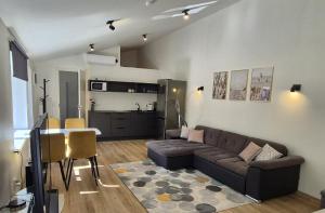 a living room with a couch and a kitchen at Pärnu Saunamaja saun, aed, mere lähedal ja tasuta parkimine in Pärnu