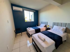 a bedroom with two beds and a window at Apto com 2 quartos e A/C no Centro in Montes Claros