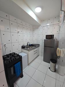 a small kitchen with a stove and a refrigerator at Apto com 2 quartos e A/C no Centro in Montes Claros