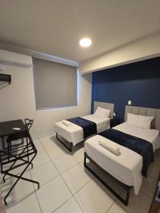 a room with two beds and a projection screen at Apto com 2 quartos e A/C no Centro in Montes Claros