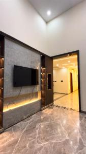 a living room with a flat screen tv on a wall at Hotel Del Luna in Greater Noida