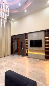 a living room with a tv on a wall at Hotel Del Luna in Greater Noida