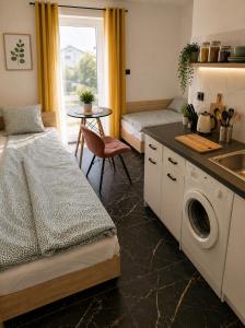 a kitchen with a bed and a washing machine at Powidz Comfort Suites in Powidz