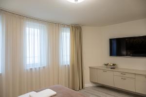 a bedroom with a bed and a tv and a window at Nádor Rezidencia in Győr