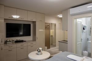 a bathroom with a television and a table with flowers at Nádor Rezidencia in Győr +136 photos