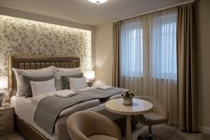 a bedroom with a bed and a table and a chair at Nádor Rezidencia in Győr