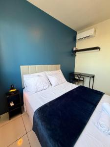 a bedroom with a large bed with a blue wall at Apto com 2 quartos e A/C no Centro in Montes Claros