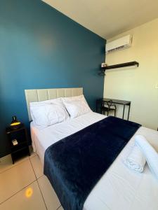 a bedroom with two beds and a blue wall at Apto com 2 quartos e A/C no Centro in Montes Claros
