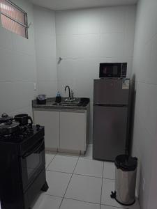 a small kitchen with a stove and a refrigerator at Apto com 2 quartos e A/C no Centro in Montes Claros