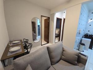 a living room with a couch and a table and a mirror at Apto com 2 quartos e A/C no Centro in Montes Claros