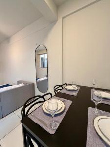 a dining room with two tables and a mirror at Apto com 2 quartos e A/C no Centro in Montes Claros