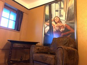 ein Bild einer Frau an einer Wand neben einem Stuhl in der Unterkunft Hotel Villa Escale in De Panne
