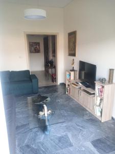 a living room with a couch and a tv at Proche CENTRE VILLE - BALCON - VUE - Calme in Igoumenitsa +3 photos