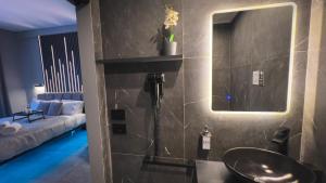 a bathroom with a sink and a mirror and a couch at HeySuite Trastevere GuestHouse ROMA in Rome