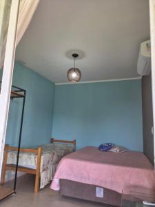 a bedroom with a bed and a blue wall at orquídea in Paulínia
