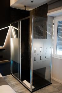 a glass shower in a room with a sign at HeySuite Trastevere GuestHouse ROMA in Rome