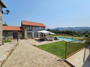 a house with a patio and a swimming pool at Quinta da Cachada in Lousada