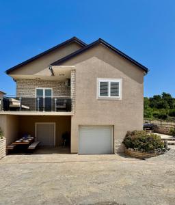 a house with two garage doors in front of it at Villa Vuletic in Kula Atlagić