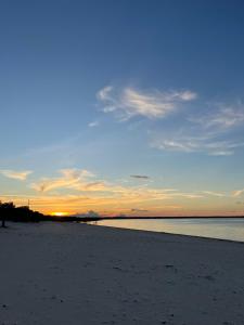 a sunset on a beach with the ocean in the background at Praia Grande Ecolodge in Manacapuru