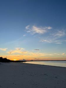 a sunset on a beach with the ocean in the background at Praia Grande Ecolodge in Manacapuru