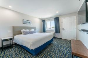 a hotel room with a bed and a table at The Grove at Pismo Beach in Pismo Beach