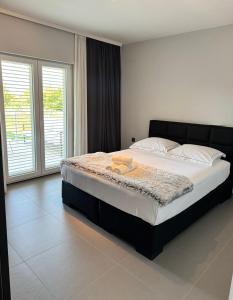 a bedroom with a large bed with a black headboard at Villa Vuletic in Kula Atlagić +16 photos