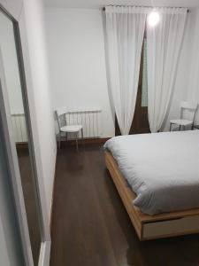 a bedroom with a bed with white curtains and a window at Villa Sojuela Green in Sojuela