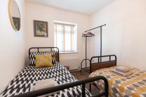 a bedroom with two beds and a mirror at JACKS COTTAGE - Cosy Cottage in the Heart of Richmond in Richmond