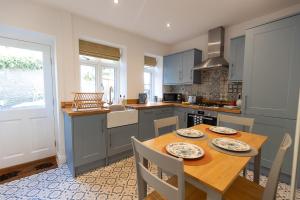 a kitchen with a wooden table and a table and chairs at JACKS COTTAGE - Cosy Cottage in the Heart of Richmond in Richmond +29 photos