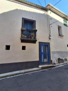 a building with a window with a blue door and flowers on it at Authentique maison de village à Agde avec patio in Agde