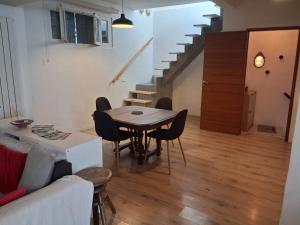 a living room with a table and chairs and stairs at Authentique maison de village à Agde avec patio in Agde +27 photos