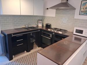 a kitchen with a sink and a stove top oven at Authentique maison de village à Agde avec patio in Agde
