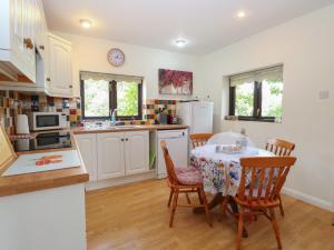 a kitchen with a table and chairs in a kitchen at Lowbrook Cottage in Diss
