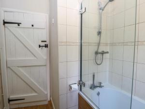 a bathroom with a shower and a bath tub at Lowbrook Cottage in Diss +13 photos