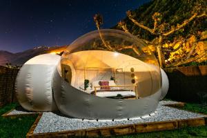 a glass dome house sitting on the grass at night at Burbujas a las puertas de Andorra in Argolell