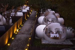 a row of white domes with lights on a sidewalk at Burbujas a las puertas de Andorra in Argolell +1 photo