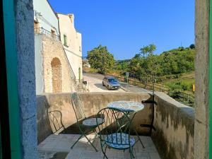 a balcony with two chairs and a table and a car at Case Vacanza Al Borgo Antico in Vico del Gargano