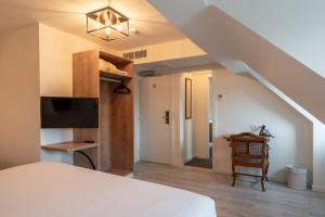 a bedroom with a bed and a staircase with a tv at Hotel Bryghia in Bruges