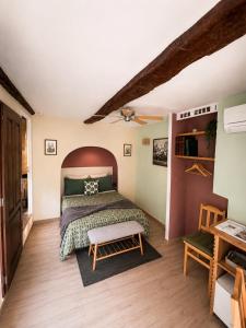 a bedroom with a bed and a wooden floor at Lou Mistral - chambres de charme climatisées, centre historique in Moustiers-Sainte-Marie