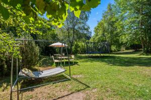 a chair and an umbrella in a yard at Großer Garten mit Grill,-Spiel und Sitzmöglichkeiten-umgeben von schöner Natur-Ferienhaus Albmatte in St. Blasien