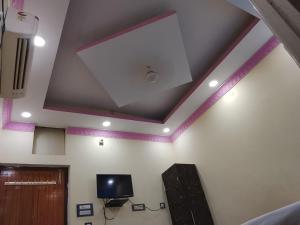 a room with a white ceiling with a tv and a speaker at Hotel Jagdamba Residency in Chupra
