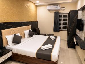 a hotel room with a bed with towels on it at Hotel GVR Prime in Guntūr
