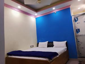 a bed in a room with a blue wall at Hotel Jagdamba Residency in Chupra
