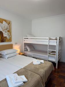 two beds in a room with two bunk beds at MJ Guest House in Póvoa de Varzim +150 photos
