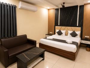 a hotel room with a bed and a chair at Hotel GVR Prime in Guntūr