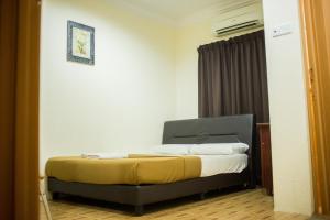 ein Schlafzimmer mit einem Bett in einem Zimmer in der Unterkunft Menara One Hotel in Kota Bharu